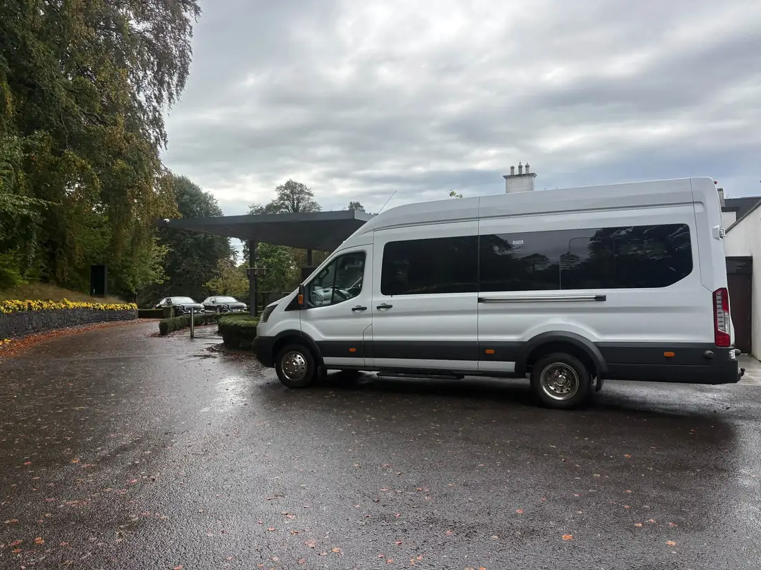 The Abel Travel minibus parked at the entrance of the Galgorm resort on a wet autumn day